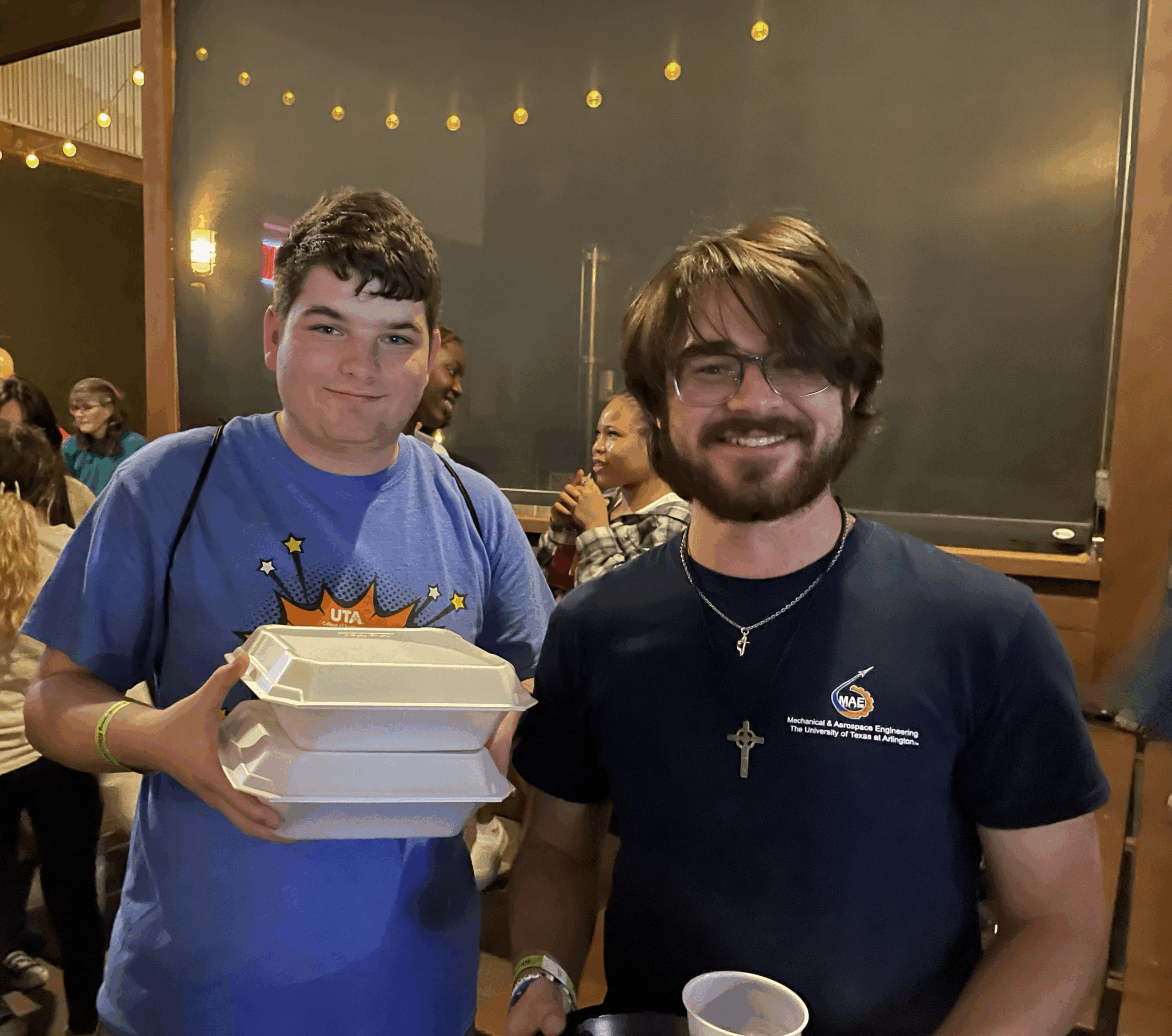 Young Adults RGMC people sitting on chair in front of table while holding pens during daytime