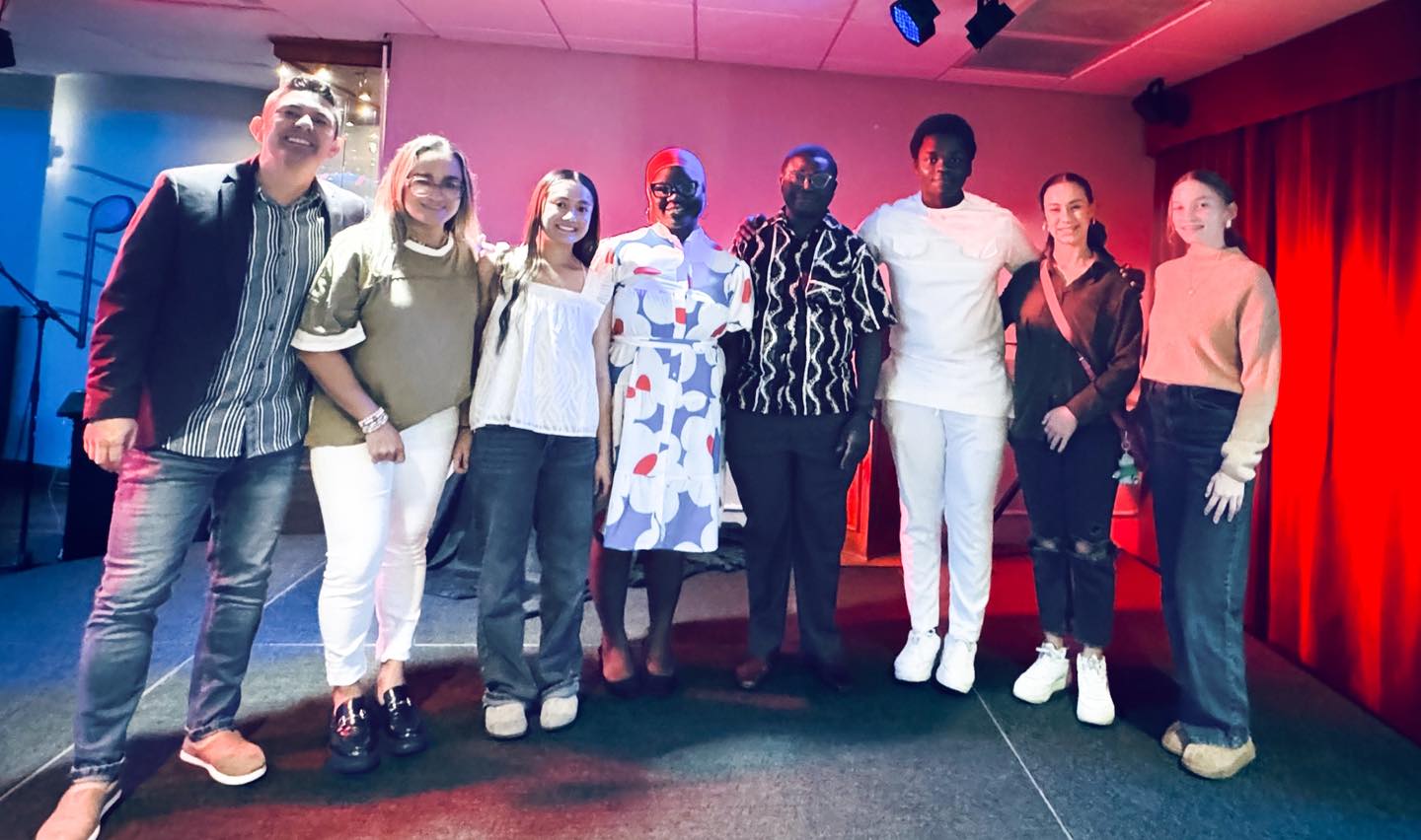 student ministry people sitting on chair in front of table while holding pens during daytime